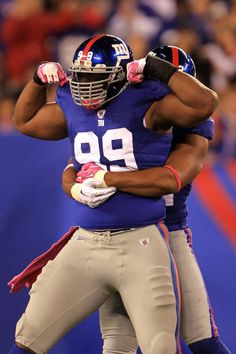 two football players hugging each other on the field