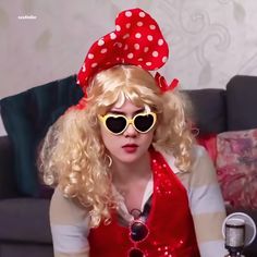 a woman with blonde hair wearing sunglasses and a red polka dot bow on her head