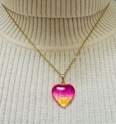 Add a touch of whimsy and color to your outfit with this stunning Gradient Heart-shaped Glass Pendant on 18K Gold Plated Chain! Featuring beautiful ombré colors in shades of pink/ yellow (Warm Blush), purple/ green (Aurora Borealis), purple/ blue (Night Sky), red (Rose) and black (Midnight), this unique pendant is sure to stand out.   An 18k gold-plated stainless-steel chain completes the look. Perfect for adding a pop of color to any look, this necklace makes for a truly special gift idea for yourself or a loved one. Handmade with care, this glass heart necklace is great for any occasion and ready to add that extra flair to your jewelry collection. Product info: *Glass heart pendant is ~2 cm x ~2 cm *18k gold plated stainless steel link cable chain necklace fully extended is ~18 inches *H Rainbow Heart Necklaces As Gifts, Heart-shaped Rainbow Necklace For Gift, Trendy Heart Print Jewelry For Gifts, Rainbow Necklace For Valentine's Day Gift, Trendy Yellow Gold Heart Necklace, Trendy Glass Jewelry As A Gift, Rainbow Jewelry For Valentine's Day Gift, Resin Heart Charm Pendant Jewelry, Yellow Heart-shaped Jewelry For Valentine's Day