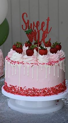 a pink cake with strawberries and white frosting