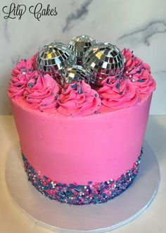 a birthday cake with pink frosting and blue sprinkles on the top