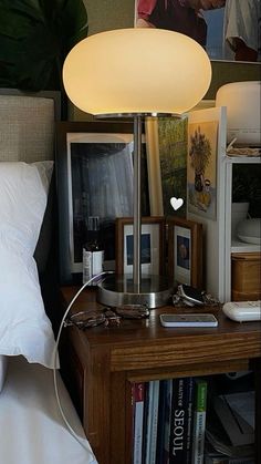 a lamp that is sitting on top of a table next to a bed and books