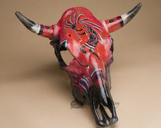 a red bull skull with black horns and designs on it's face is shown