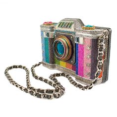 Capture the admiring glances of everyone around you when you wear this colorful crossbody camera handbag! This camera-shaped handbag is features hand-laid beading in the colors of the rainbow, as well as a fun, vibrant interior! 7.75 x 2.5 x 4.5" Strap Length End to End: 50.5" Strap Drop: 23" Non-removable crossbody woven chain strap, magnet closure, inside pocket, metal logo fob, protective storage bag, certificate of authenticity, fits a phone, vegan leather This is a handmade item, each one a Mary Frances Handbags, Modern Handbag, Novelty Purses, Mary Frances, Woven Chain, Color Of Life, Metallic Logo, Phone Bag, Fashion Handbags