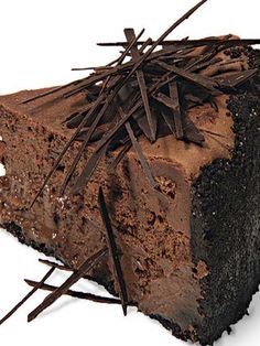 a piece of chocolate cake with sticks sticking out of it's center, on a white background