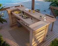 an outdoor dining table on a deck overlooking the ocean