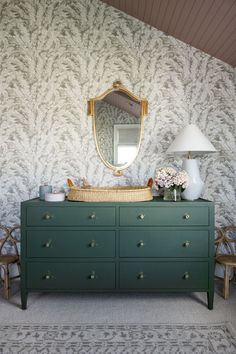 a green dresser and mirror in a room