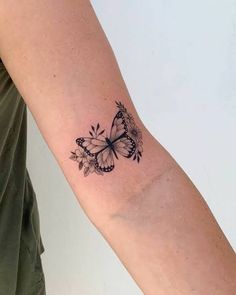 a woman's arm with a butterfly tattoo on the left side of her arm