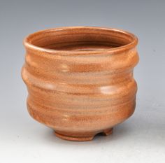 a brown vase sitting on top of a white table