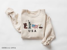 USA Flag Sweatshirt * Product Details - Printed with ink - Unisex Sweatshirt - Designed with pre-shrunk soft air-jet spun yarn - Features a crewneck - Double-needle stitched collar, shoulders, armholes, cuffs and hem - Loose fit for a comfortable feel * Sizing and Colors - Please refer to sizing and color charts in the images * Fabrication - 50% cotton, 50% polyester * Care Instructions - Turn inside out and machine wash cold on delicate cycle - Dry on low heat setting - Do not bleach - Do not d Patriotic Tops With Letter Print For Fall, Patriotic Letter Print Tops For Fall, Patriotic Fall Tops With Letter Print, Patriotic Crew Neck T-shirt For Fall, Fall Patriotic Crew Neck T-shirt, White Long Sleeve T-shirt For 4th Of July, Relaxed Fit Crew Neck Shirt Made In Usa, Long Sleeve Cotton Tops For 4th Of July, Cotton Long Sleeve Top For 4th Of July