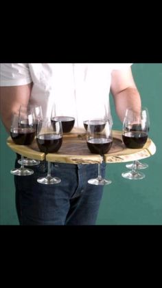 a man holding a tray with wine glasses on it