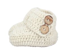 a pair of white crocheted slippers with wooden buttons on the front and bottom