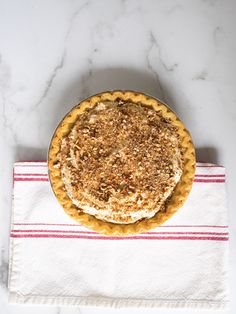 a pie sitting on top of a white table next to a red and white towel