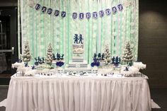 a table topped with a cake covered in blue and white frosted snowflakes