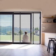 a person sitting in front of a sliding glass door