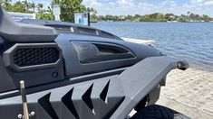 the front end of a vehicle parked next to a body of water