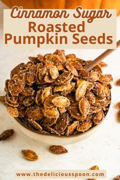 cinnamon sugar roasted pumpkin seeds in a white bowl with a wooden spoon and text overlay that reads, cinnamon sugar roasted pumpkin seeds