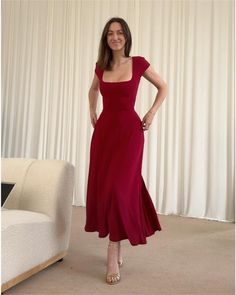 a woman in a red dress posing for the camera