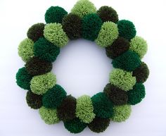 a green and brown pom - pom wreath on a white background