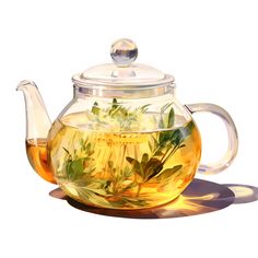 a glass tea pot filled with green leaves