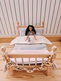 a doll sitting on top of a wooden bed