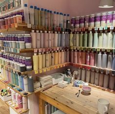 there are many different shades of paint on the shelves in this shop, and one is being used as a wallpaper