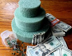 a stack of money sitting on top of a wooden floor next to stacks of cash