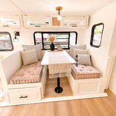 the inside of a recreational vehicle with two couches and a dining table in it