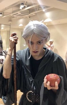 a woman with grey hair holding an apple