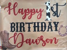 a happy 1st birthday sign with cowboy boots and horseshoes on it's side