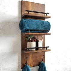 a towel rack with two towels hanging from it's sides and some other items on the shelf