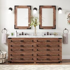 two sinks and mirrors in a bathroom with wooden cabinets, white walls and wood flooring