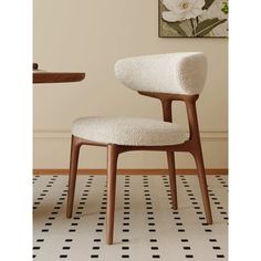 a white chair sitting on top of a black and white checkered floor next to a table