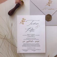 the wedding stationery is laid out on top of an envelope and wax stamper