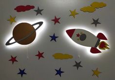 two wall lights that have rockets and stars on them in front of a white wall