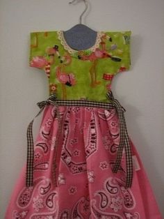 a pink and green dress hanging on a wall