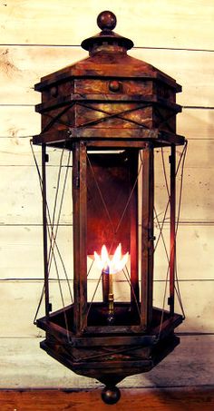 an old fashioned lantern with two lit candles in it