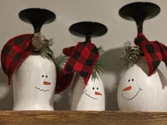 three snowmen with hats and scarfs on their heads are lined up in a row