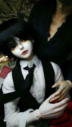 two mannequins dressed in black and white clothing, one holding a doll's hand