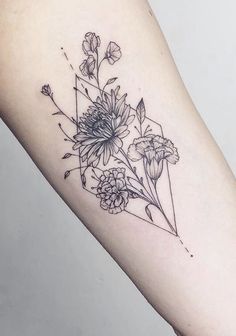 a black and white photo of flowers on the arm, with geometric shapes in the background