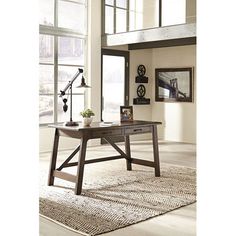 a wooden table sitting on top of a rug in front of a window with lots of windows