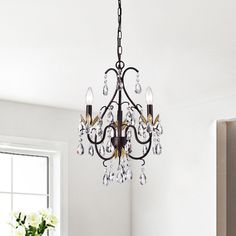 a chandelier hanging from the ceiling in a room with white walls and windows