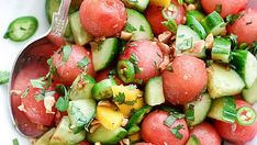 a white bowl filled with cucumber and tomato salad