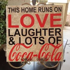 a sign that says, this home runs on love laughter and lots of coca - cola