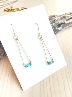 Beautiful 14K Gold Filled wire triangle drops with rich Turquoise gemstones and solid gold accent beads. They measure approximately 2.25 inches from the top of the ear wire.These are lightweight, fun and perfect for everyday. All of our handcrafted items arrive wrapped, perfect for gift giving!Made in the USA. Bead Wrapped Earrings, Minimalist Jewelry Making, Geometric Wire Earrings, Simple Beaded Jewelry Ideas, Simple Metal Earrings, Simple Wire Wrapped Jewelry, Boho Beaded Jewelry, Gemstone Earrings Handmade, Made Jewelry Ideas