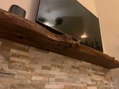 a flat screen tv mounted on top of a wooden mantle