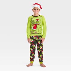 Surprise your kid during Christmas with The Grinch 2-Piece Cozy Pajama Set and Santa Hat. This two-piece pajama set includes a green sleep shirt, a pair of black pajama pants and a Santa hat for a festive look. The top showcases a print of the Grinch wearing a Santa outfit on skis with "Merry Grinchmas" text, while the bottom showcases allover Grinch faces wearing Santa hats and the name "Grinch" for holiday fun. Grinch Faces, Black Pajama Pants, Grinch Pajamas, The Grinch Christmas, Black Pajamas, Merry Grinchmas, Santa Outfit, Cozy Pajamas, Santa Hats