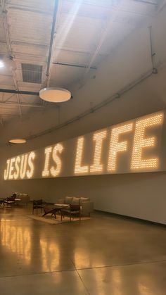 the words jesus is life projected in an empty room