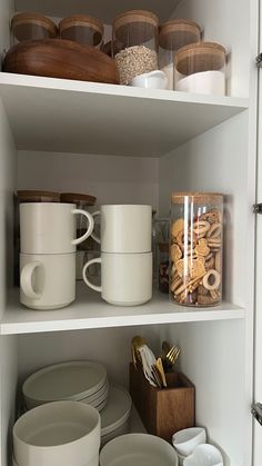 the shelves are filled with dishes, cups and other kitchen utensils on them