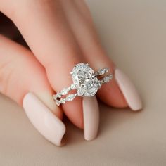 a woman's hand with a ring on her finger and manicured nails in the foreground